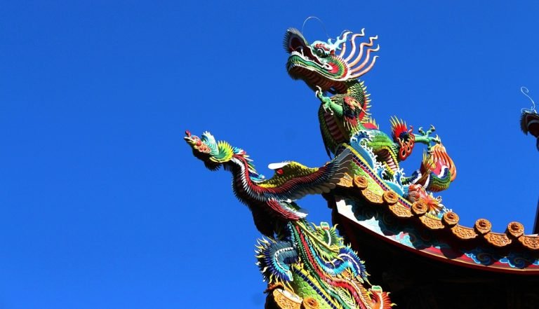 Is Taiwan safe - vibrant dragon sculpture on a Taiwanese temple roof against blue sky