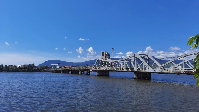 Things to do in Kampot - River bridge with mountains and calm waterfront scenery
