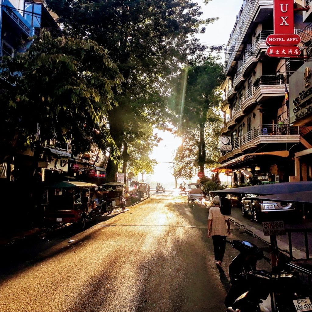 cost of traveling in cambodia morning street scene phnom penh tuk tuks sunlight