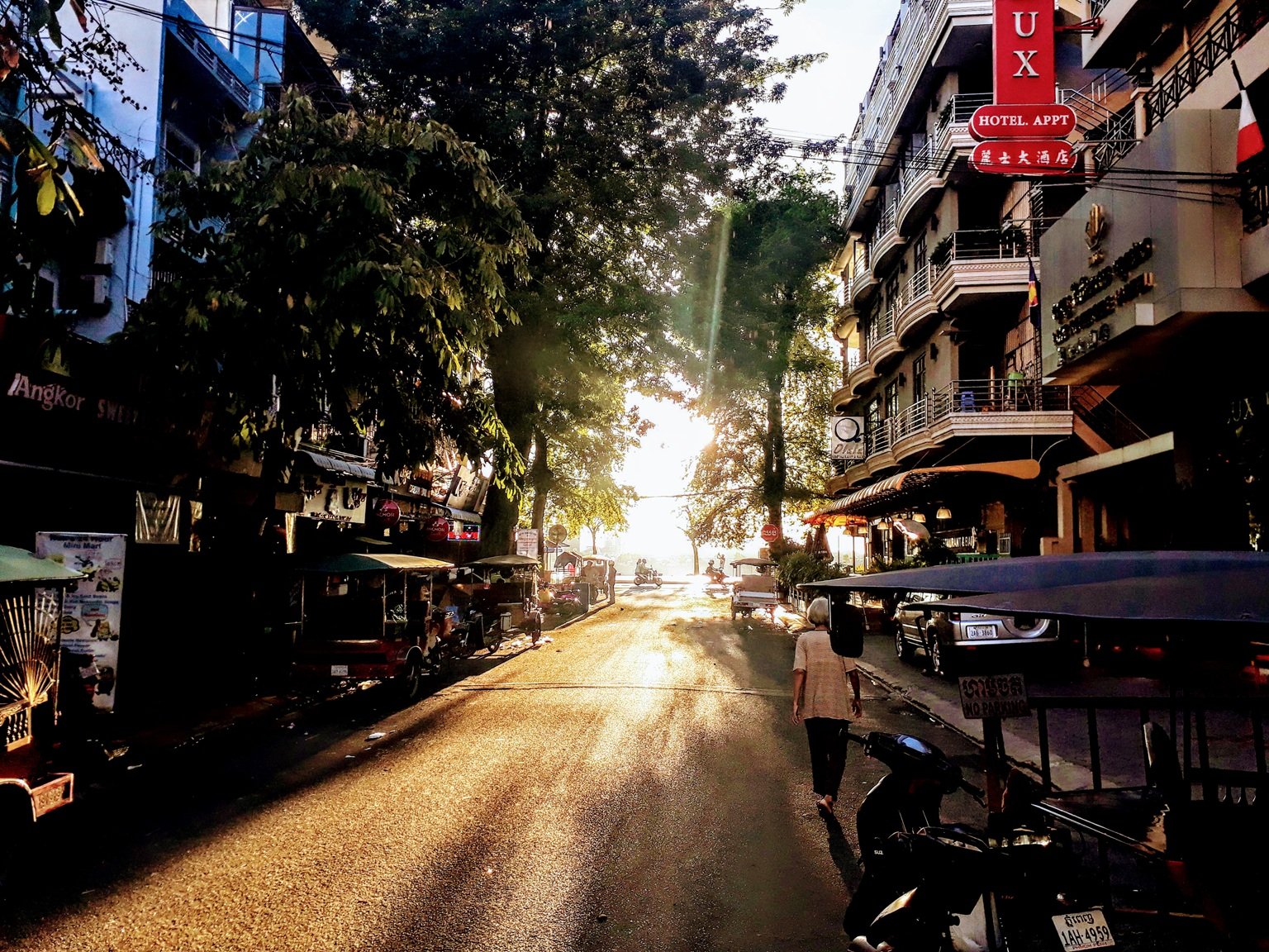 cost of traveling in cambodia morning street scene phnom penh tuk tuks sunlight