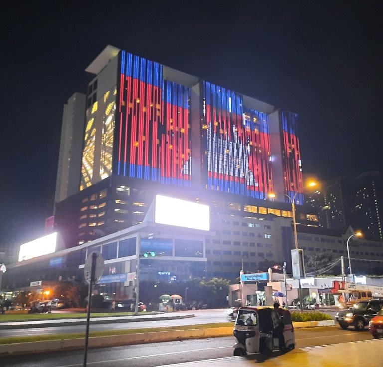 NagaWorld casino and hotel in Phnom Penh illuminated at night with city traffic