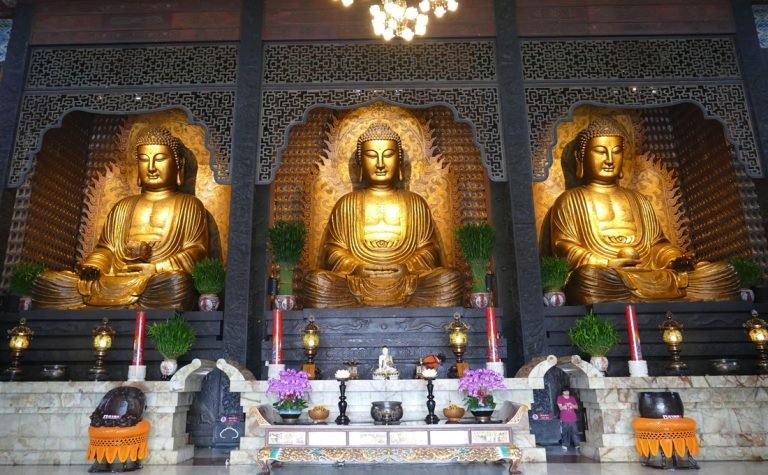 Is Taiwan safe interior of Taiwanese temple with golden Buddha statues and calm atmosphere Caption Description