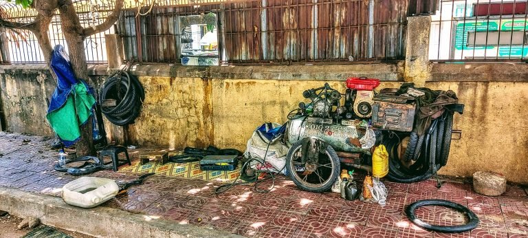 Things to do in Phnom Penh roadside mechanic repair shop street scene Cambodia