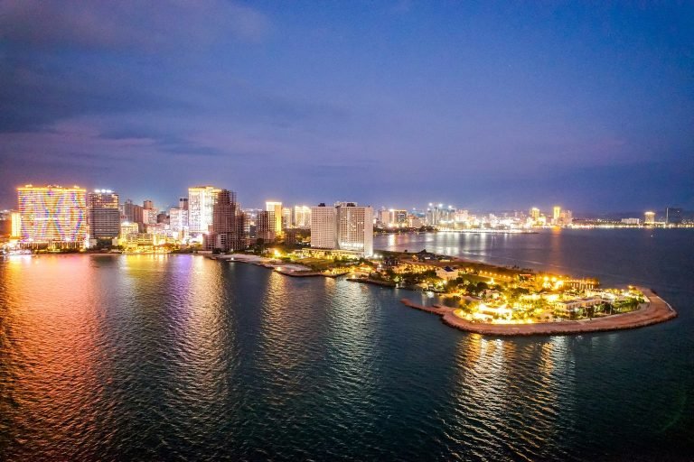 Sihanoukville Cambodia coastline at night with illuminated skyline and waterfront lights reflecting on the sea Caption: Description: