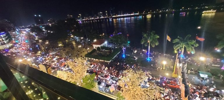 Things to do in Phnom Penh riverside esplanade at night with crowds and city lights