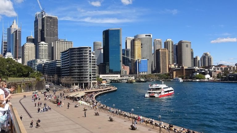 Sydney travel tips: Circular Quay waterfront with ferry and Sydney skyline on a clear day