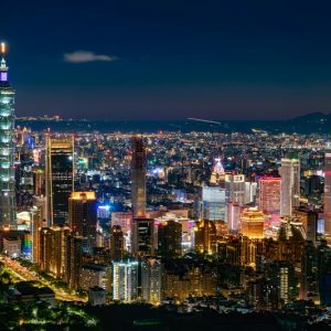 High-angle night view of the illuminated Taipei 101 skyscraper and bright city skyline, perfect for Taiwan travel tips.