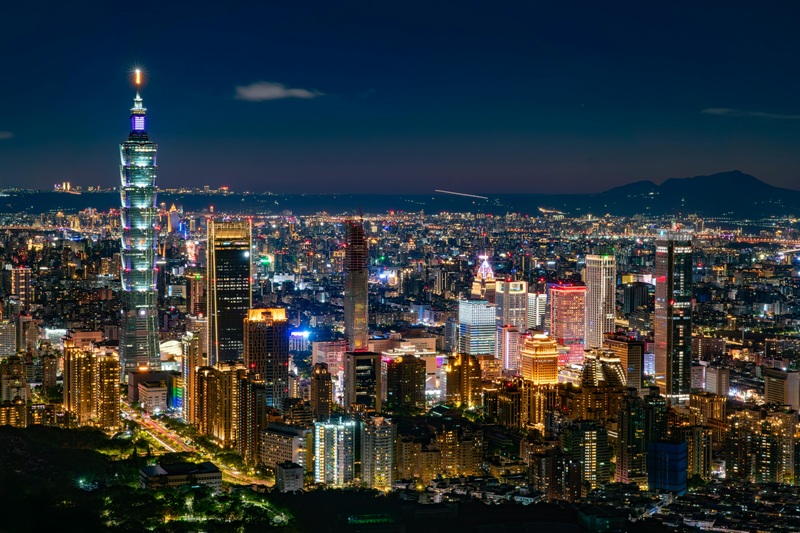 High-angle night view of the illuminated Taipei 101 skyscraper and bright city skyline, perfect for Taiwan travel tips.