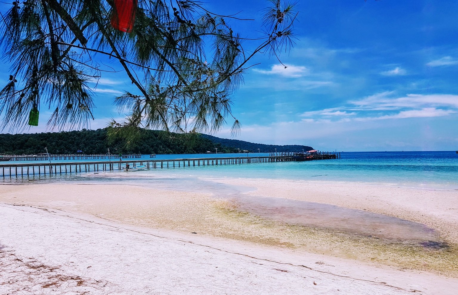 Koh rong samloem beach with white sand, turquoise water, and wooden pier stretching into the sea