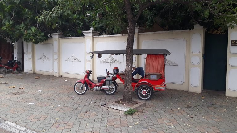 Tuk-tuk parked on a quiet street in Phnom Penh showing local transport during the best time to visit Cambodia