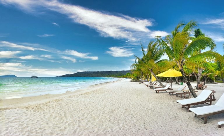 Koh Rong beach with white sand, palm trees, and lounge chairs facing the turquoise sea Caption: Description: