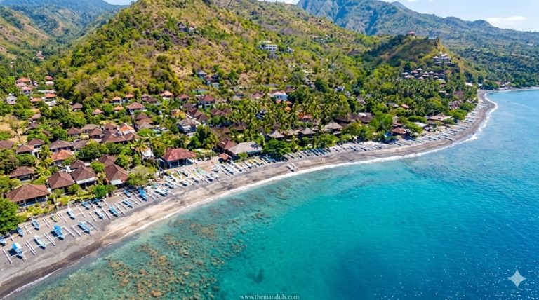 Black sand coastline and turquoise water at Amed Beach in East Bali surrounded by fishing villages and hills
