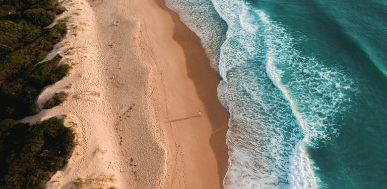 Aerial view of waves rolling onto a pristine shoreline at one of the beautiful beaches in Sydney Caption: Description: