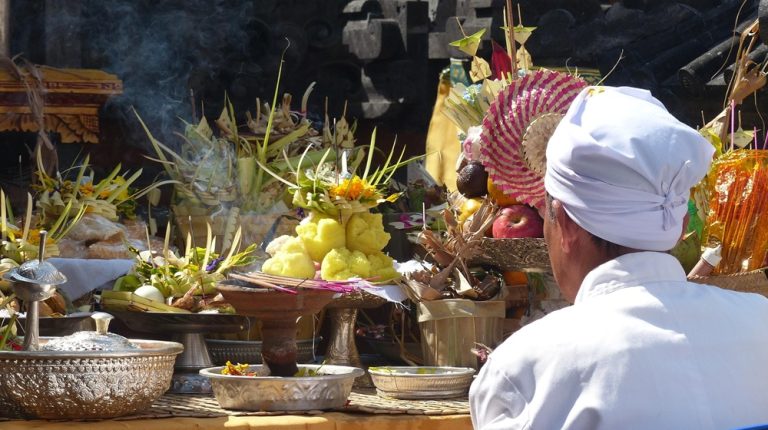 Balinese Hindu ceremony with traditional offerings at a temple, showcasing cultural experiences accessible when learning how to get around Bali
