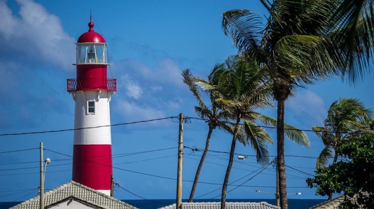 Barra Lighthouse in Salvador Brazil with palm trees and blue sky along the Atlantic coast