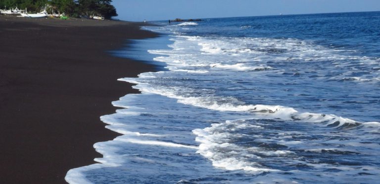 Black sand beach along Bali's eastern coastline, highlighting how to get around Bali and discover lesser-known coastal destinations Caption: Description: