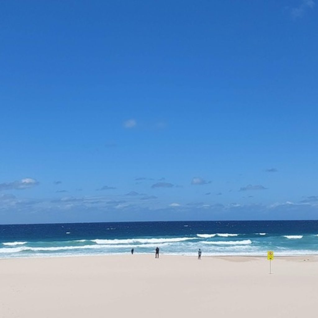 Wide sandy shoreline and ocean waves at Bondi Beach, one of the most famous beaches in Sydney