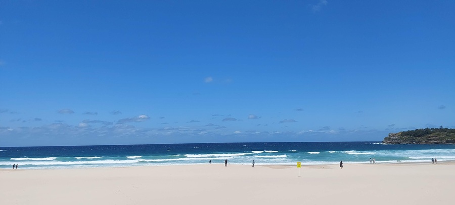 Wide sandy shoreline and ocean waves at Bondi Beach, one of the most famous beaches in Sydney