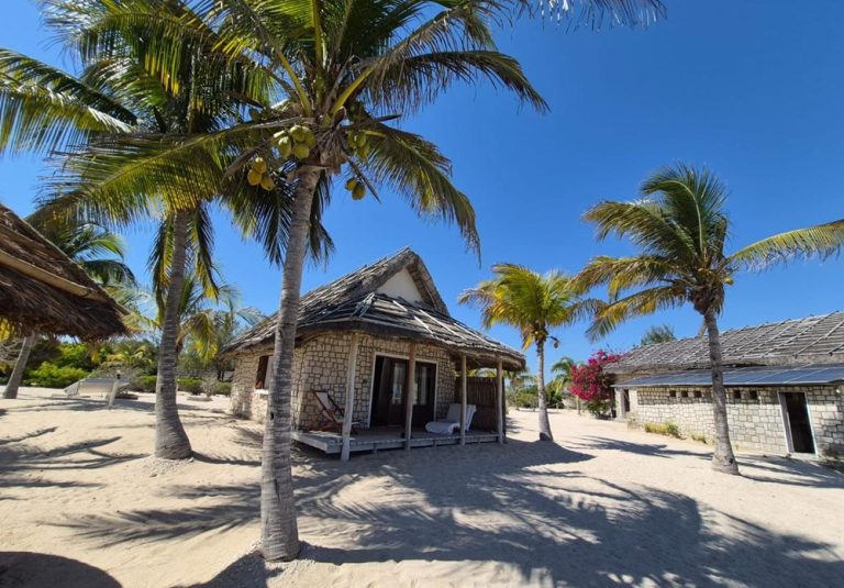 Bungalows en pierre et palmiers sur une plage tropicale près de Tuléar à Madagascar Caption Description