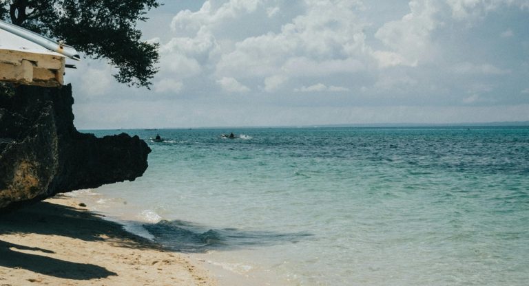 Clear turquoise shoreline and calm waves at Crystal Beach on the coast of Nusa Penida
