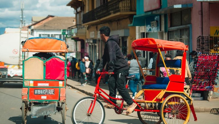 Cyclo-pousses circulant dans une rue commerçante animée à Madagascar Caption Description