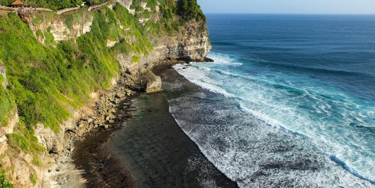 Steep limestone cliffs overlooking crashing ocean waves in Uluwatu, Bali Caption: Description:
