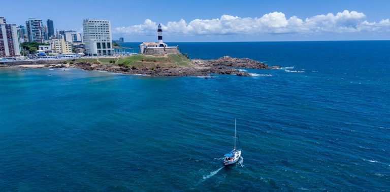 Aerial view of Farol da Barra in Salvador Brazil with sailboat and deep blue Atlantic Ocean