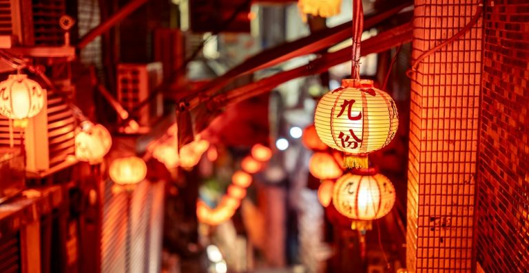 Traditional red lanterns glowing above a narrow alleyway in Jiufen, Taiwan