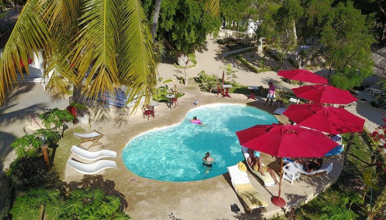 Vue aérienne de la piscine de l’Ifaty Beach Club Resort entourée de palmiers à Madagascar Caption Description
