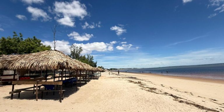 Plage de sable blanc avec paillotes traditionnelles lors d’un itinéraire Madagascar Caption :