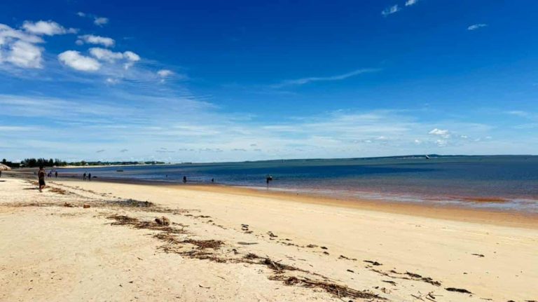 Grande plage de sable blanc avec lagon calme et ciel bleu sur la côte de Madagascar