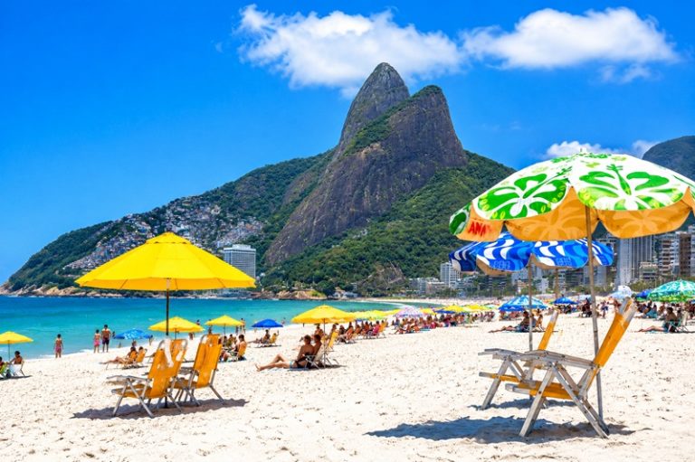Beaches in Brazil with umbrellas and white sand in Rio de Janeiro under blue skies