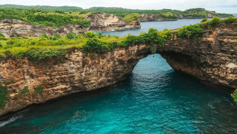 Natural rock arch and turquoise ocean near Diamond Beach in Bali beaches around Nusa Penida Caption: Description: