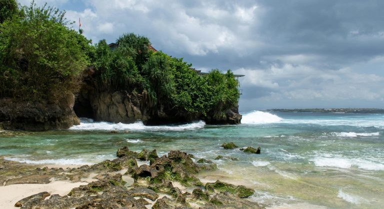 Rocky shoreline and turquoise water at Padang Padang Beach in Bali beaches along the Uluwatu coastline