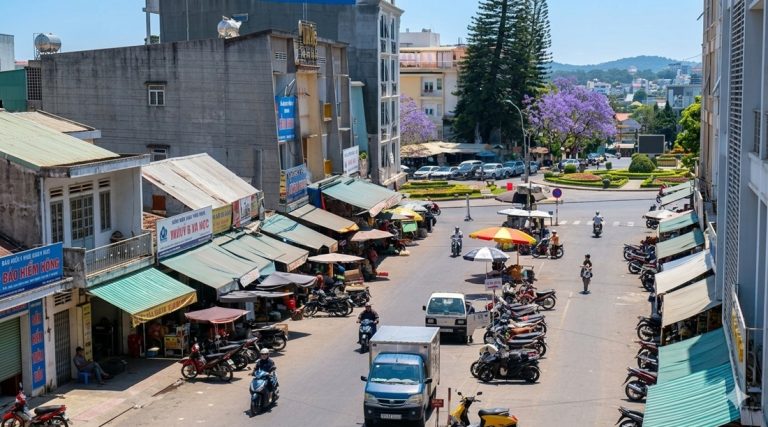 Rue animée à Antananarivo avec commerces, scooters et activité quotidienne en ville