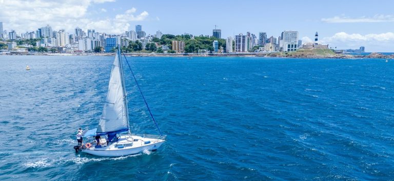 Sailboat sailing along the coastline of Salvador Brazil with ocean views and city skyline