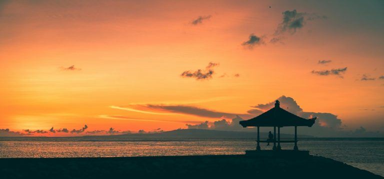 Traditional seaside pavilion silhouetted against a colorful sunrise in Sanur, Bali Caption: Description: