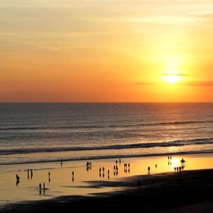 Sunset over Seminyak Beach showing travelers enjoying the shoreline during golden hour, illustrating how getting around Bali and explore its coastal destinations