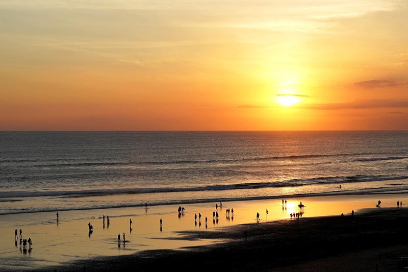 Sunset over Seminyak Beach showing travelers enjoying the shoreline during golden hour, illustrating how getting around Bali and explore its coastal destinations