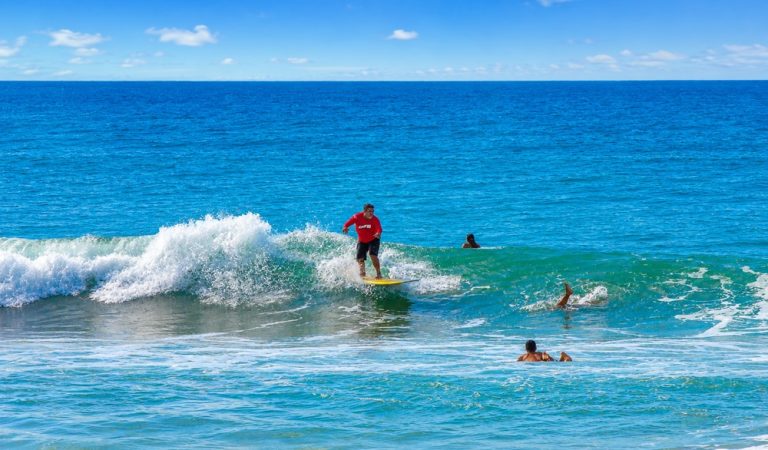 Surfer riding waves on a sunny beach featured in this Northeast Brazil travel guide