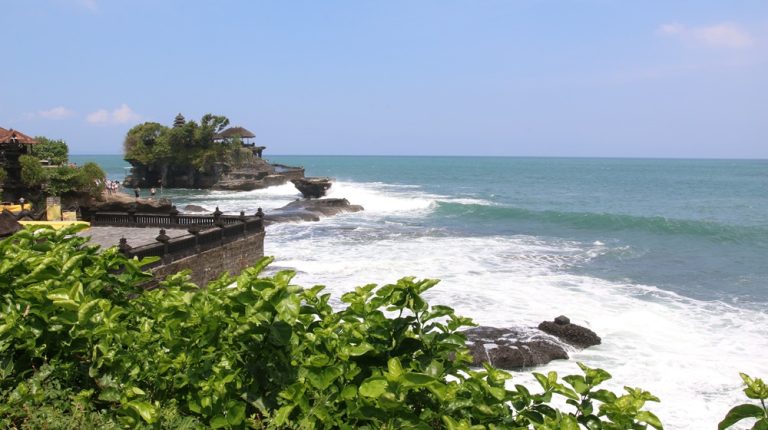 Ocean waves crashing near Tanah Lot temple coastline in Bali beaches along the island’s western shore
