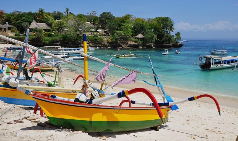 Traditional fishing boats on a tropical beach during a Bali itinerary exploring Bali’s coastline and island culture Caption: Description: