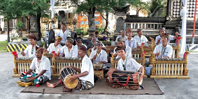 Traditional Balinese gamelan musicians performing at a cultural event in Bali, highlighting experiences accessible when learning how to get around Bali