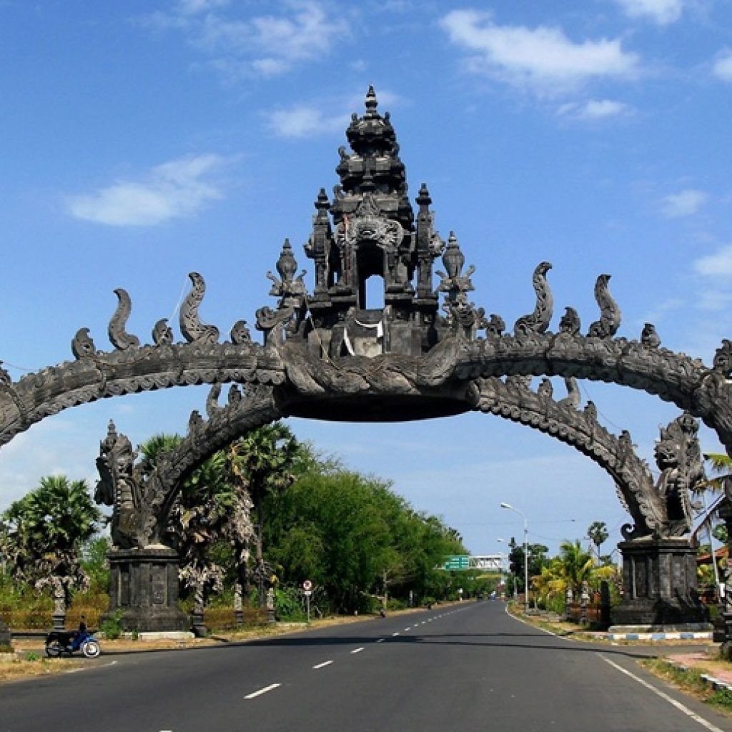 Traditional Balinese gate in Bali, Indonesia near the road entrance surrounded by blue skies and tropical scenery for where to stay in Bali travel guide