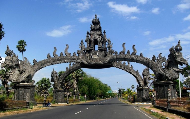 Traditional Balinese gate in Bali, Indonesia near the road entrance surrounded by blue skies and tropical scenery for where to stay in Bali travel guide