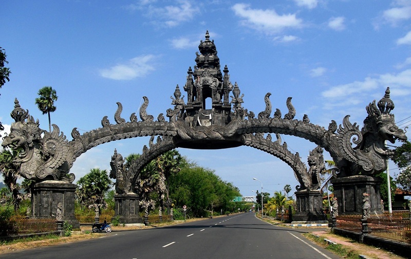 Traditional Balinese gate in Bali, Indonesia near the road entrance surrounded by blue skies and tropical scenery for where to stay in Bali travel guide