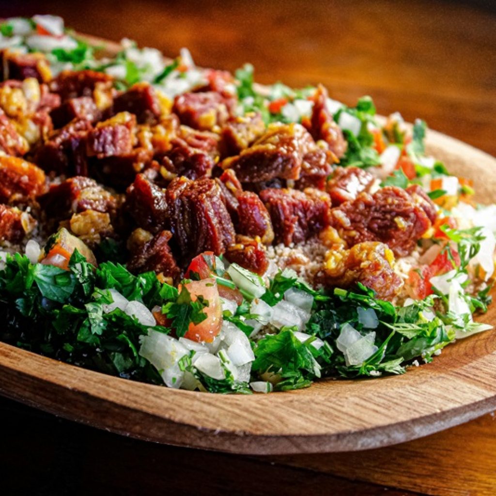 Traditional Brazilian meat dish with farofa and fresh herbs featured in this Food in Brazil travel guide