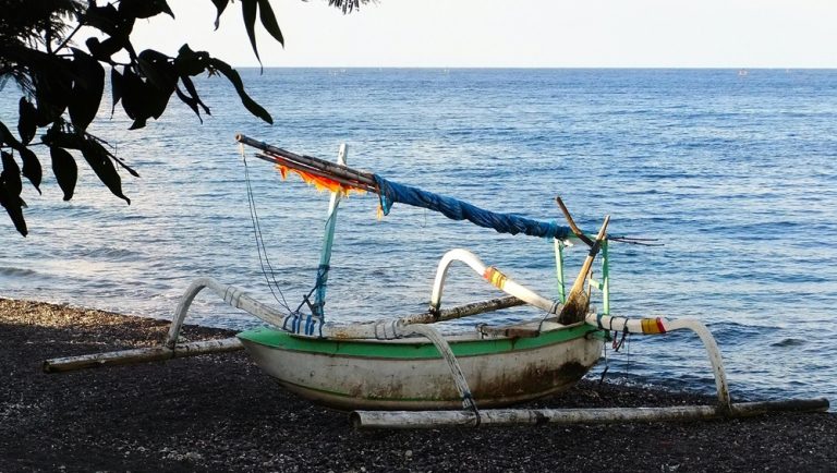 Traditional Balinese fishing boat resting on the beach in Amed, Bali