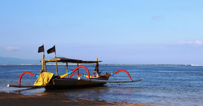 Traditional jukung fishing boat resting on a Bali beach, illustrating how to get around Bali and reach coastal villages around the island