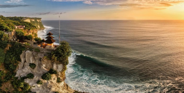 Uluwatu Temple perched on dramatic ocean cliffs at sunset, highlighting Bali travel tips for visiting the island's most iconic cultural landmarks